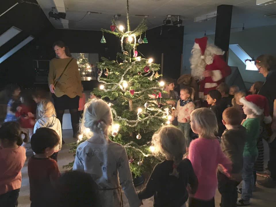 Børn danser om juletræ sammen med julemanden